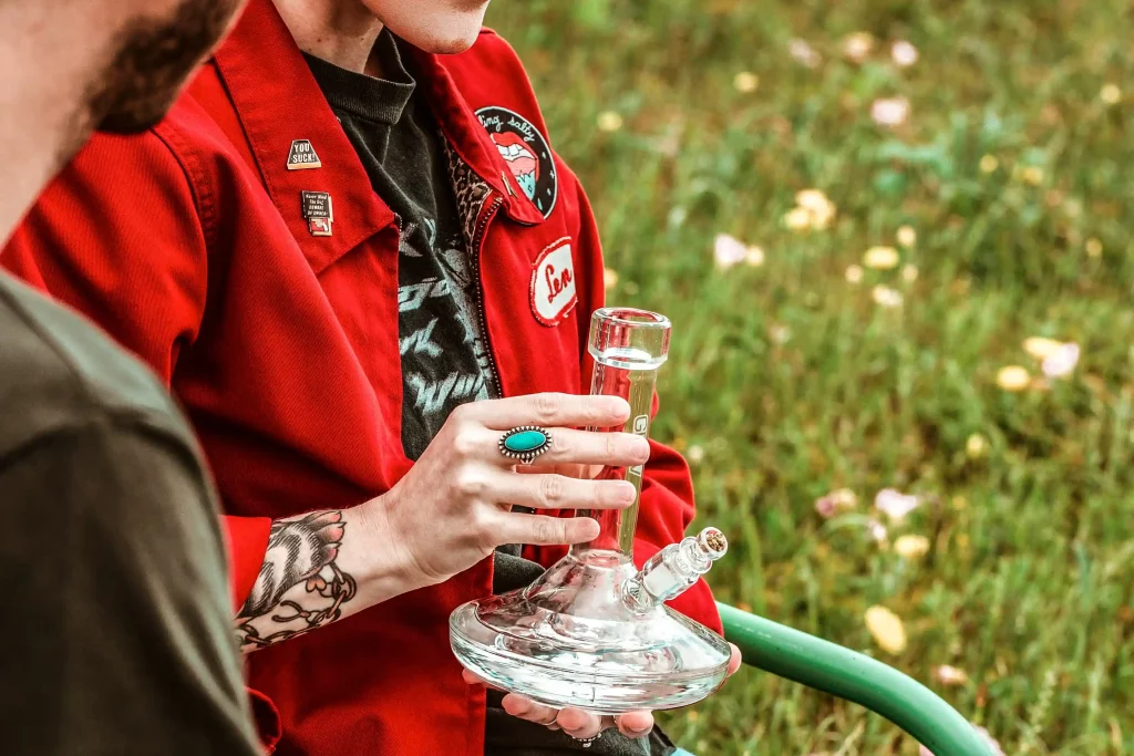 A man with a thick glass pipe in his hand